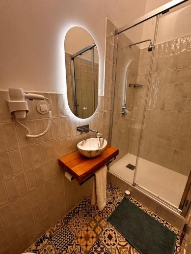 a bathroom with a sink and a shower with a mirror at Lisbon Chillout Hostel in Lisbon