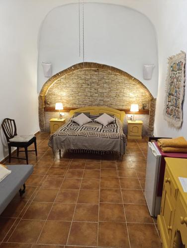 a bedroom with a bed and a brick wall at Nick's Cave, Bed and Breakfast with a difference in Cuevas del Almanzora