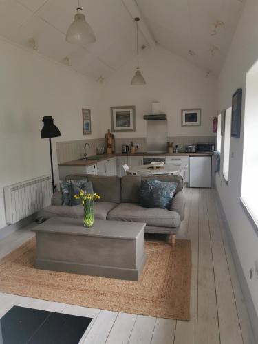 a living room with a couch and a table at The Flower House in Madron