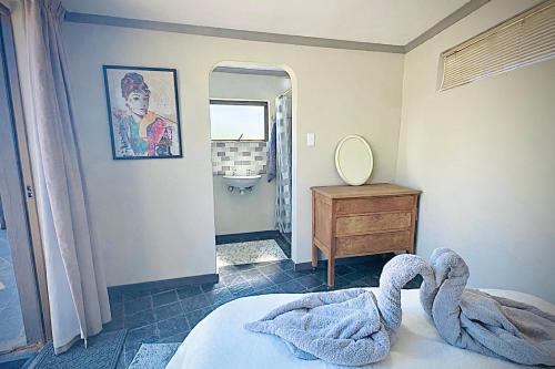 a bedroom with a bed and a mirror and a dresser at Vaal Dam Manor - Waters Edge in Oranjeville