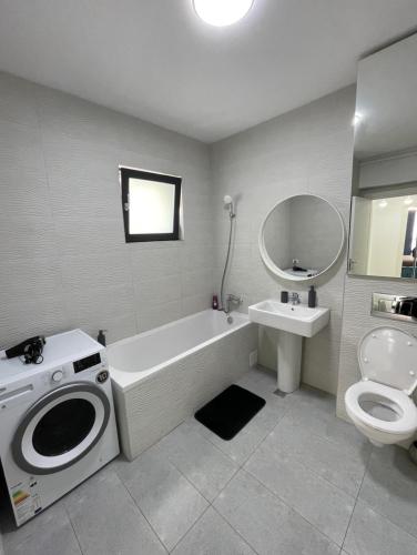 a bathroom with a tub and a toilet and a sink at App Town North Pipera 23 in Voluntari