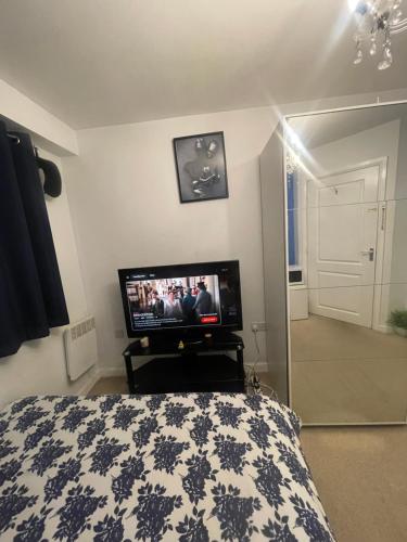 a bedroom with a bed and a flat screen tv at Urban Blue by Wolverhampton Train Station in Wolverhampton