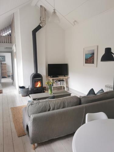 a living room with a couch and a fireplace at The Flower House in Madron