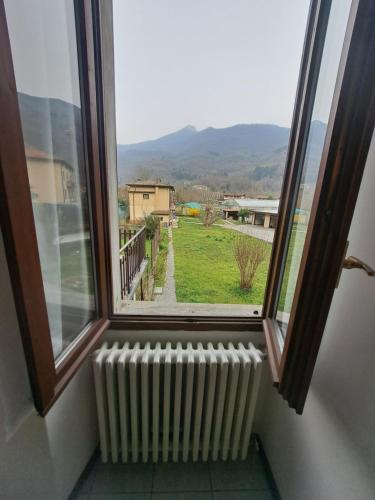 a window with a radiator and a view of a yard at Green & Blue House in Valbrona