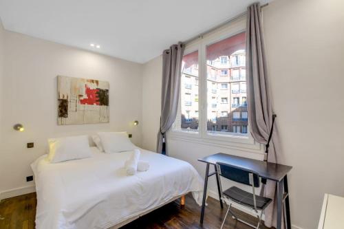 Eiffel Tower Accommodation Design في باريس: غرفة نوم بها سرير وطاولة ونافذة