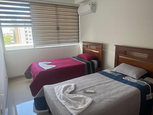 מיטה או מיטות בחדר ב-Edificio Mirador las Américas