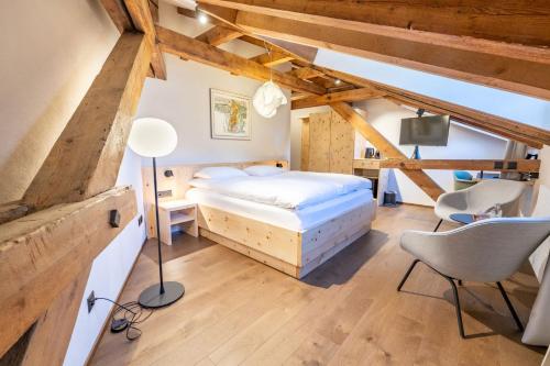 a bedroom with a bed and a desk and chairs at Hotel Stern Chur in Chur