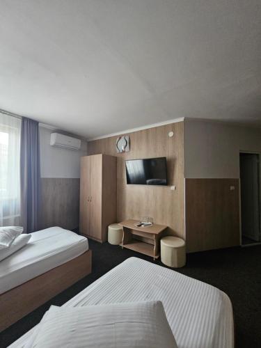 a hotel room with two beds and a desk at Pension Regal in Satu Mare