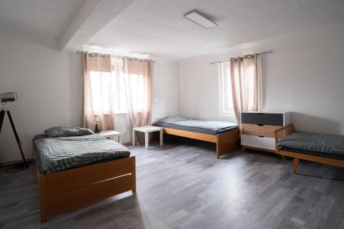 a room with three beds and a tv in it at KiRoom Willsbach 2 und 3 in Obersulm