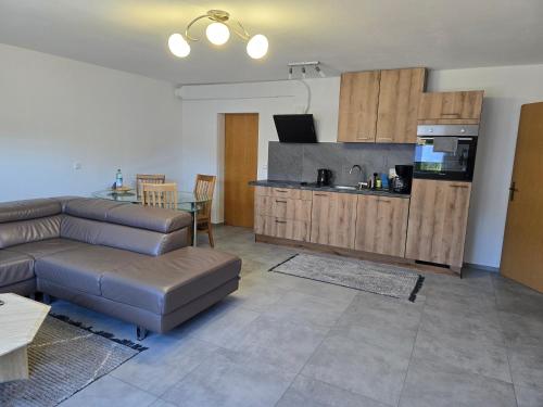 a living room with a couch and a kitchen at Ferienwohnung Baj in Albstadt