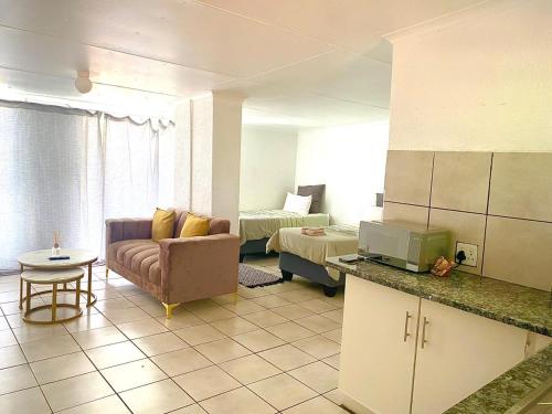 a kitchen and living room with a couch and a bed at Alldays Sunset Lodge Wilde Street in Alldays