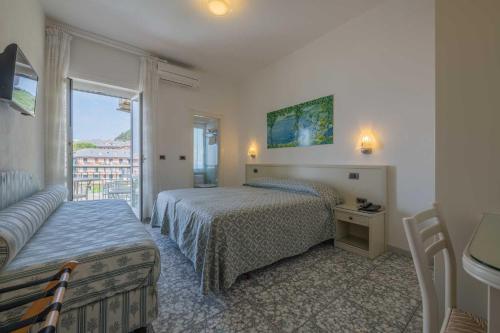 a bedroom with two beds and a window at Hotel Riviera in Deiva Marina