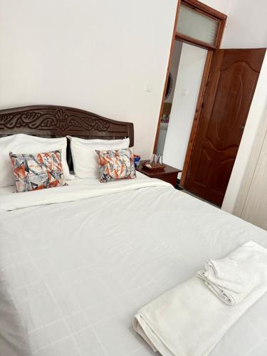 a large white bed with a towel on it at Beytumn Luxury Apartment - Ruiru in Nairobi
