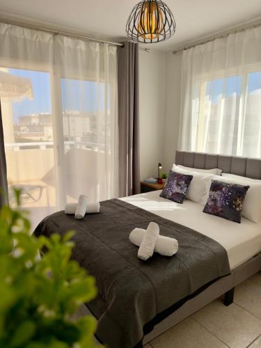 a bedroom with a bed with two towels on it at AquaSol Suite Modern 2BR with Shared Pool in Protaras