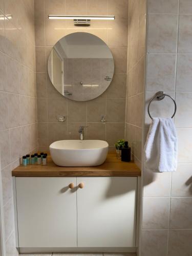 a bathroom with a sink and a mirror at AquaSol Suite Modern 2BR with Shared Pool in Protaras