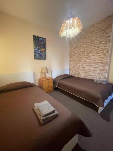 a bedroom with two beds and a chandelier at Limnaria Westpark 2 bdrm apartment 122 in Paphos