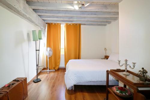 a bedroom with a white bed and an orange curtain at Duplex Sainte Trinité - Troyes Centre Historique in Troyes