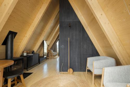 an attic living room with wooden walls and wooden floors at TheVagar - Glamping Mountain Shelters in Belmonte
