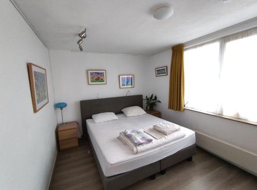 a bedroom with a bed and a large window at Quiet spacious room in Amsterdam