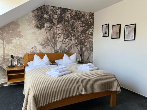a bedroom with a bed with towels on it at Penzion Luna in Brno
