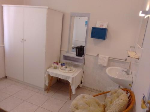 a bathroom with a sink and a table in it at Hotel Prinzessin Rupprecht in Swakopmund