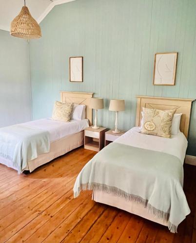 two beds in a room with wooden floors at Briar & Bloom2 in Hilton