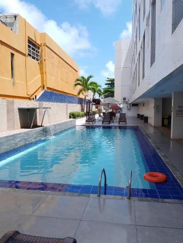 a large swimming pool in the middle of a building at Ocean Flat Tambaú in João Pessoa