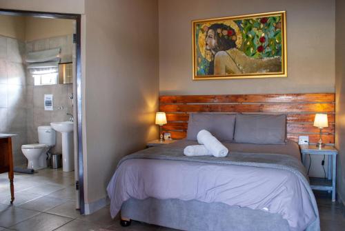 a bedroom with a bed and a painting on the wall at Casa de la Presa 4 in Polokwane