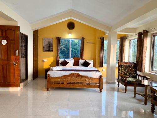 a bedroom with a large bed with yellow walls at kollanoor guest house in Madikeri
