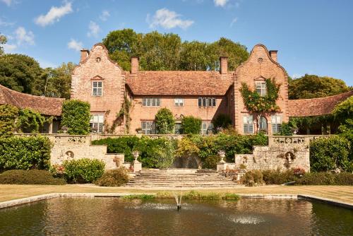 an old house with a pond in front of it at Pinewood - At Port Lympne Hotel & Reserve in Hythe