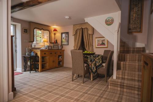 a living room with stairs and a table and chairs at Helmsley Garden Cottage & Railway Carriage in Helmsley