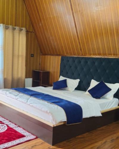 a bedroom with a large bed with a blue headboard at Lanying Riverview Homestay in Dirang Dzong