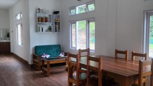 a dining room with a table and a green chair at Lanying Riverview Homestay in Dirang Dzong