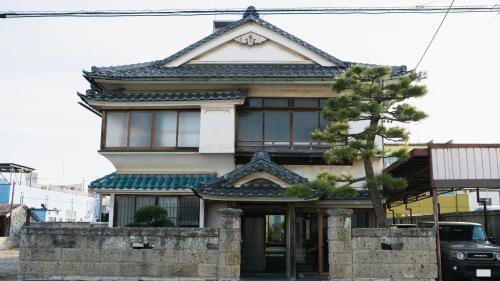 a building with an asian roof on a street at Guest House hopin in Nagano
