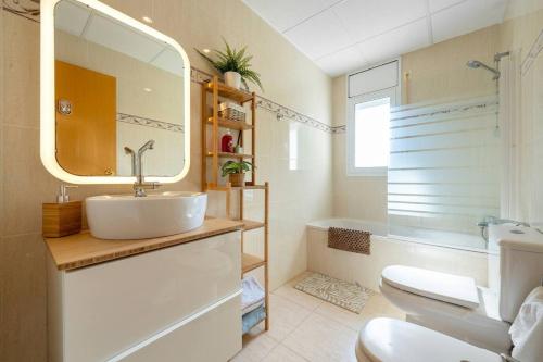 a bathroom with a sink and a toilet and a mirror at Brisa I Apartment in Montroig