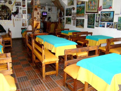 a restaurant with wooden tables and blue tables at Hotel Casa Vieja in Santa Marta