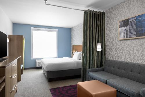 a hotel room with a bed and a couch at Home2 Suites By Hilton Phoenix Downtown in Phoenix