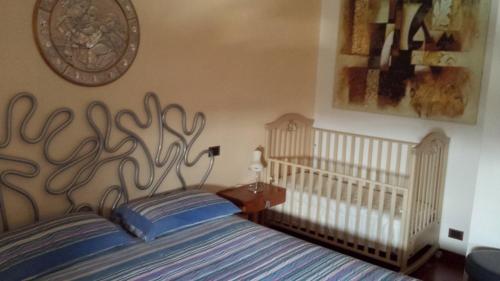 ein Schlafzimmer mit einem Bett und einem Babybett in der Unterkunft Rosej Bed & Breakfast Putignano in Putignano