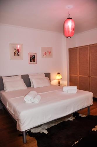 a bedroom with a large bed with two towels on it at Ilia's Coastal Apartement in Vlorë