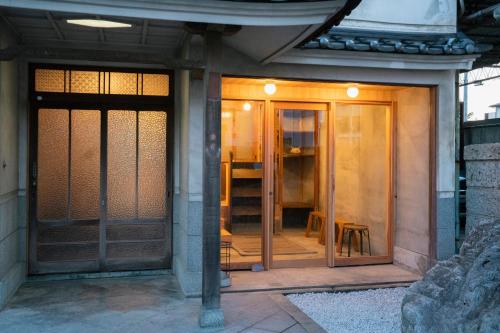 an entrance to a building with a glass door at Guest House hopin in Nagano