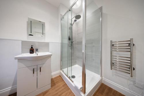 a white bathroom with a shower and a sink at The Mortimer Arms in Romsey
