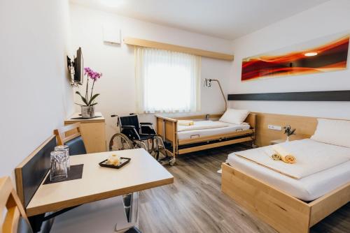 a small room with a bed and a table at Pension RoBi in Harthofen