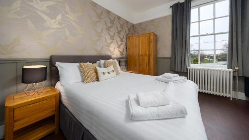 a bedroom with a large bed and a window at The Mortimer Arms in Romsey