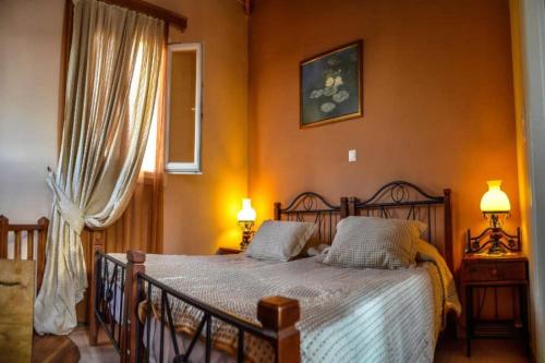 a bedroom with a bed and two lamps and a window at Mainades Maisonettes & Studios - Andros Serene Escape in Ménites