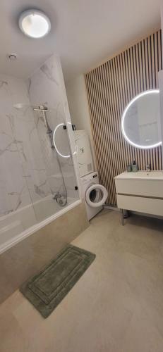 a bathroom with a tub and a toilet and a sink at Maison cosy 4-6 pers avec terrasse Lac & hyper centre à pied 300 m Linge inclus in Gérardmer