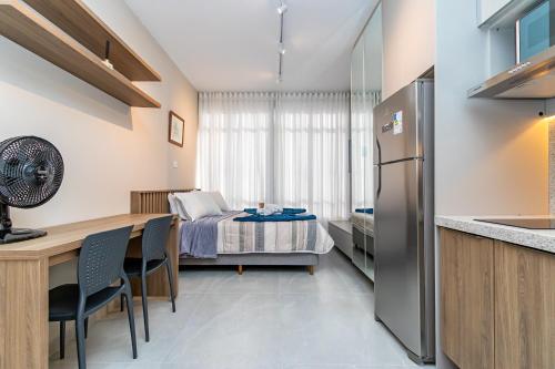 a kitchen and living room with a bed in a room at Edifício ASA- ASA001 in Curitiba
