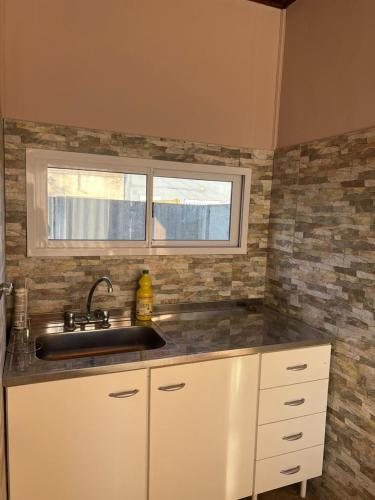 a kitchen with a sink and a window at MiniChino Casa Interna in Pehuajo