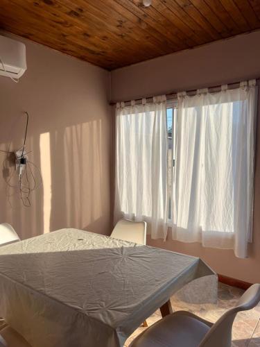 a room with a bed and a window with white curtains at MiniChino Casa Interna in Pehuajo