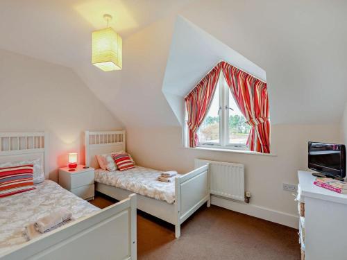 a attic bedroom with two beds and a window at 3 Bed in Chathill oc-cn001 in Beadnell