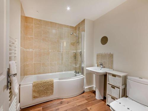 a white bathroom with a tub and a sink at 3 Bed in Chathill oc-cn001 in Beadnell